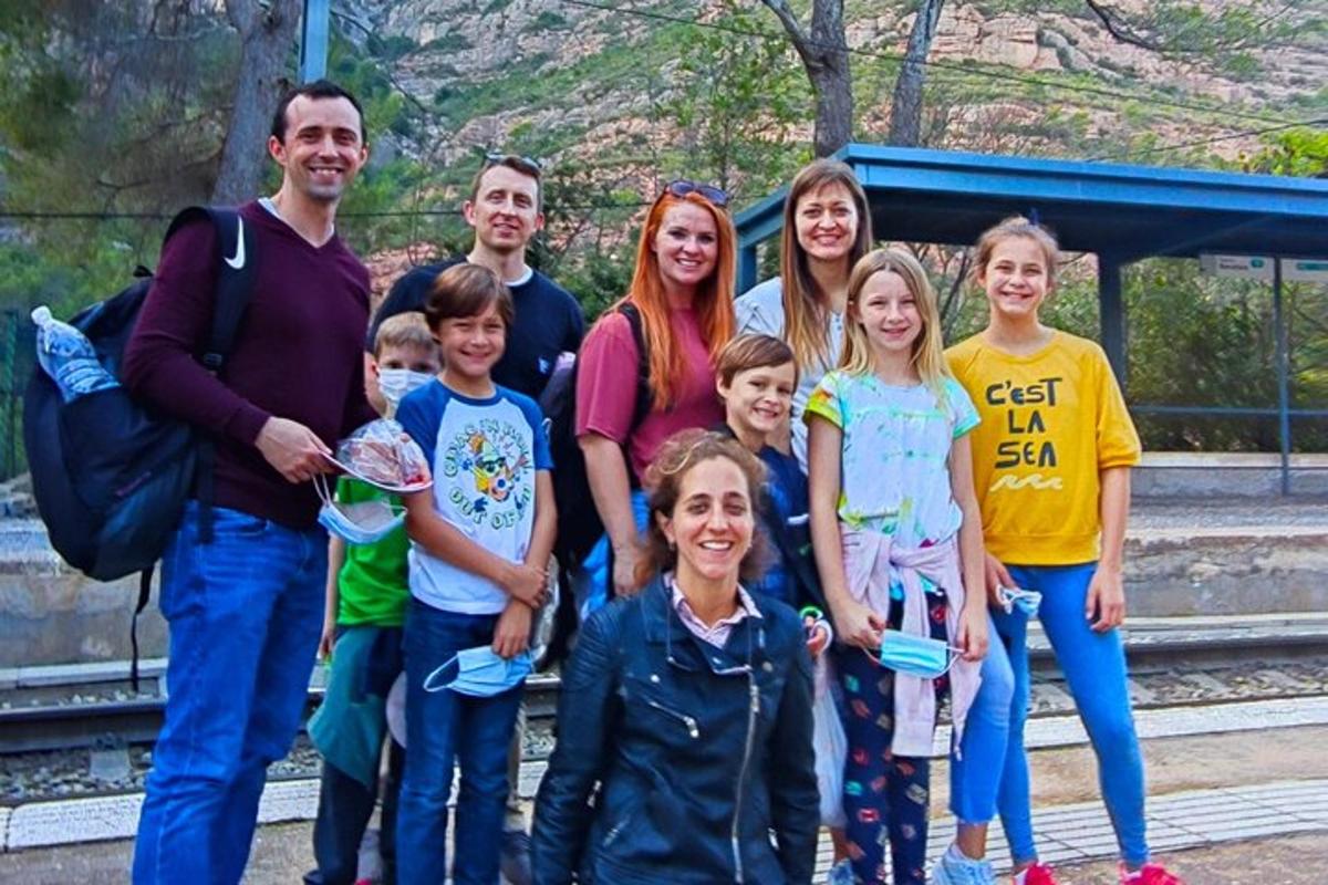 um grupo de pessoas posando para uma foto em uma estação de trem