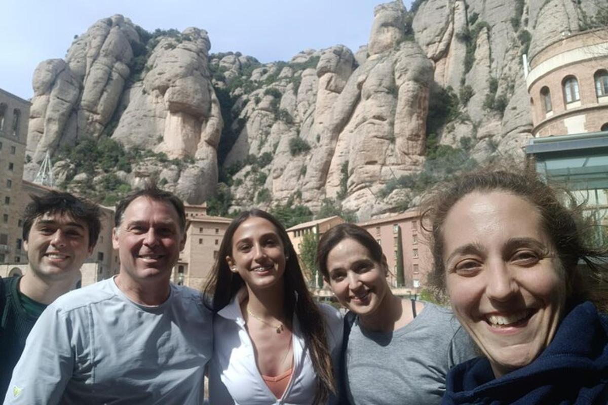 um grupo de pessoas em pé em frente a uma montanha