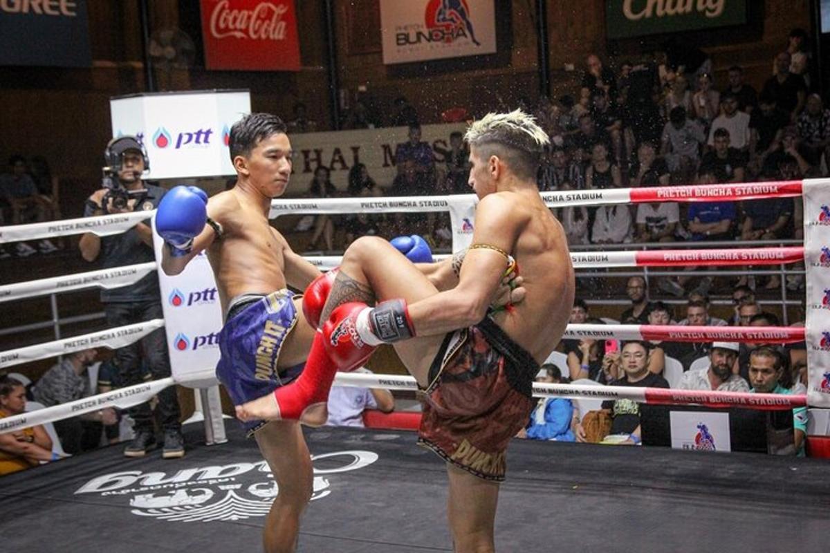two men are fighting in a boxing match