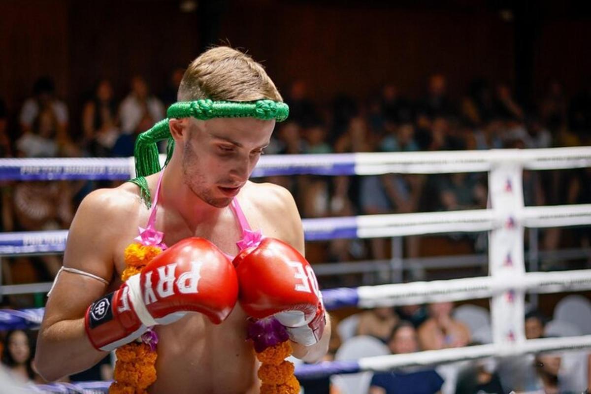 a man wearing a red boxing glove and a green headband