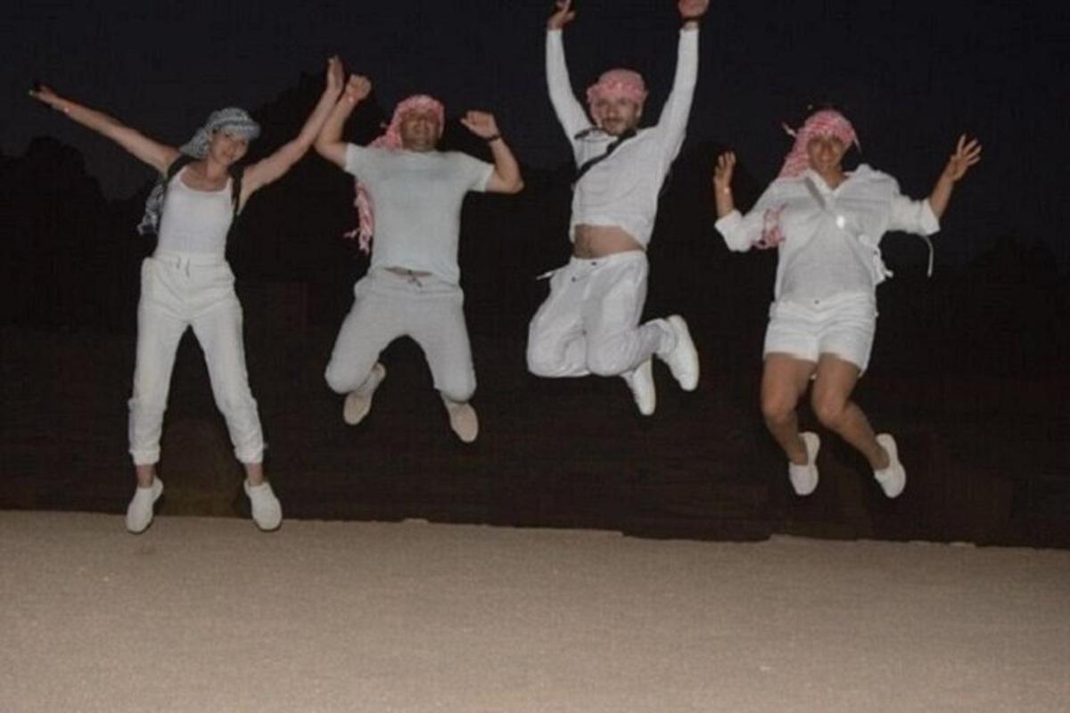 a group of four people jumping in the air