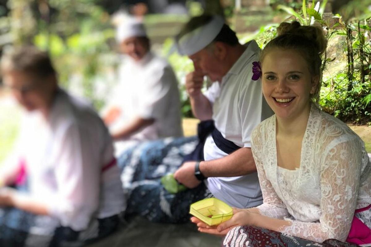 a woman in a white dress sitting next to a group of people