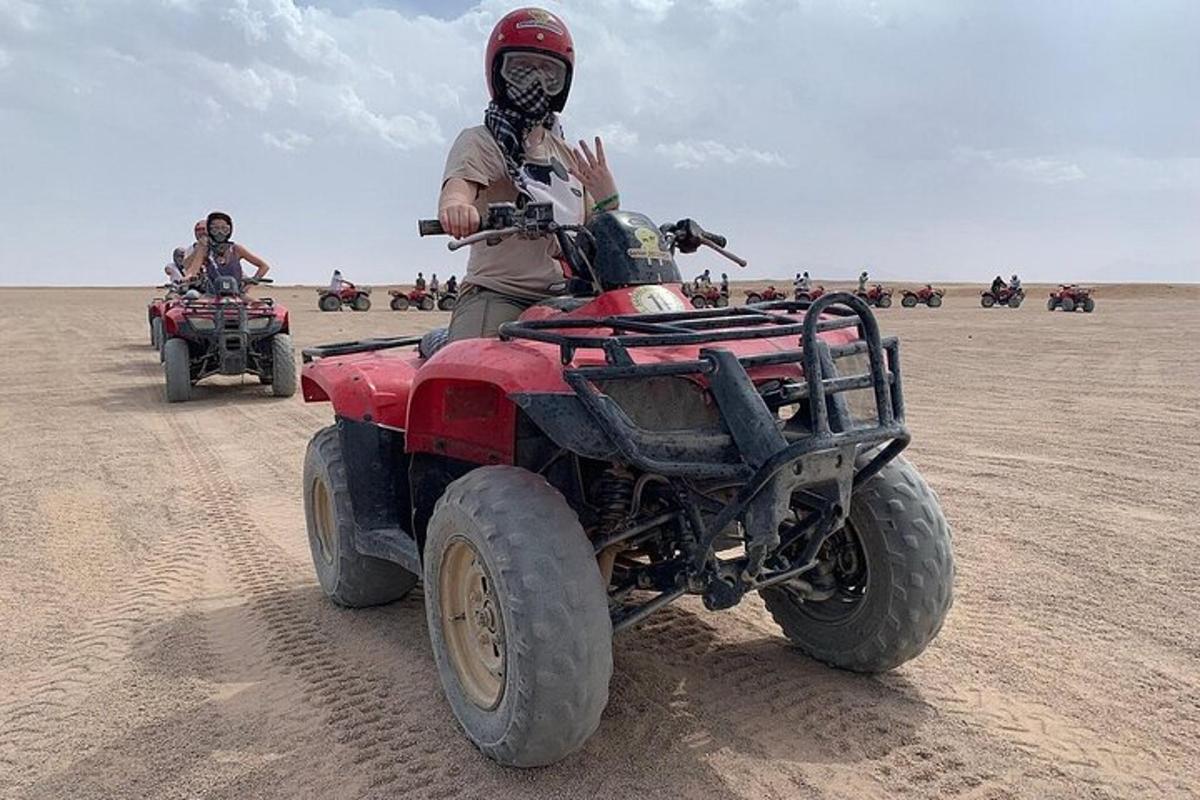 un homme sur un véhicule à quatre roues dans le désert