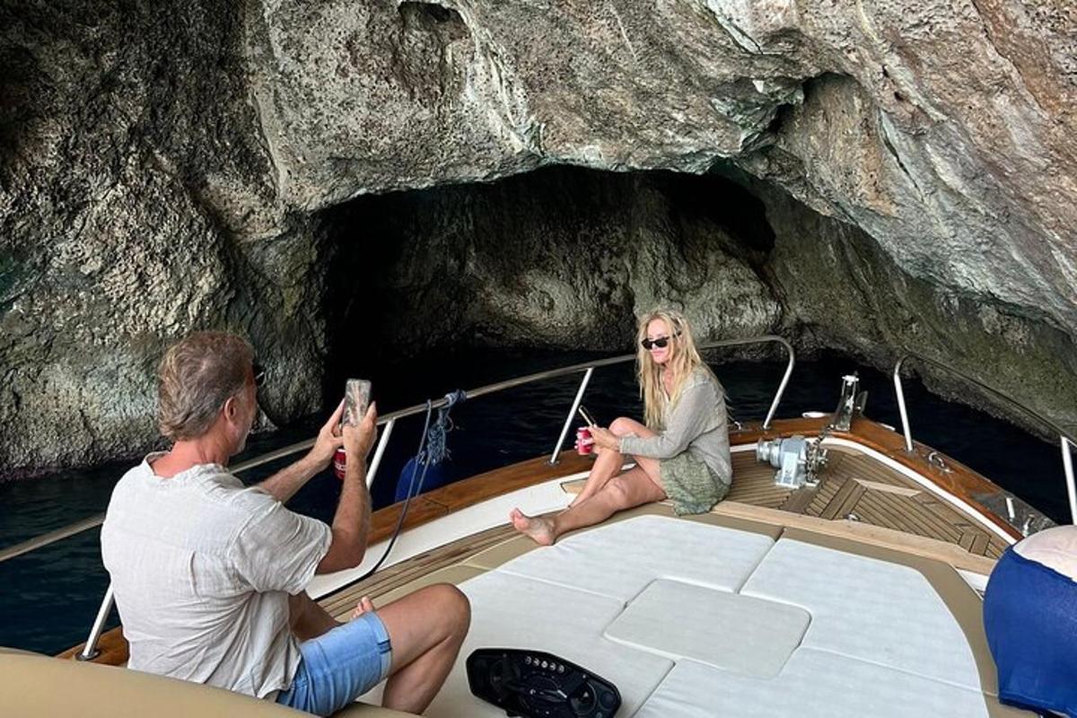 un uomo e una donna seduti su una barca in una grotta