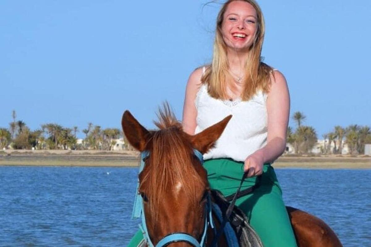 a woman riding a horse in the water