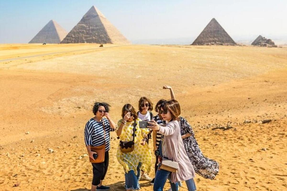 um grupo de pessoas em pé em frente às pirâmides