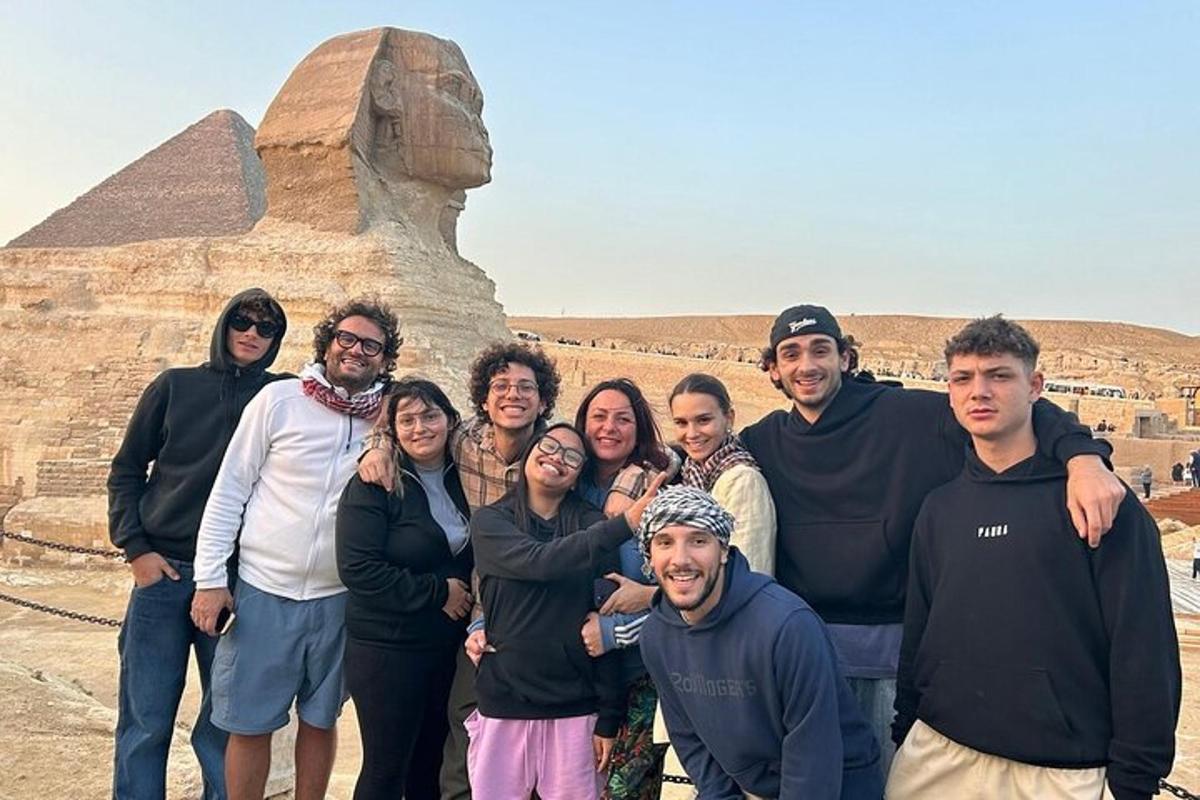 um grupo de pessoas em pé em frente à pirâmide