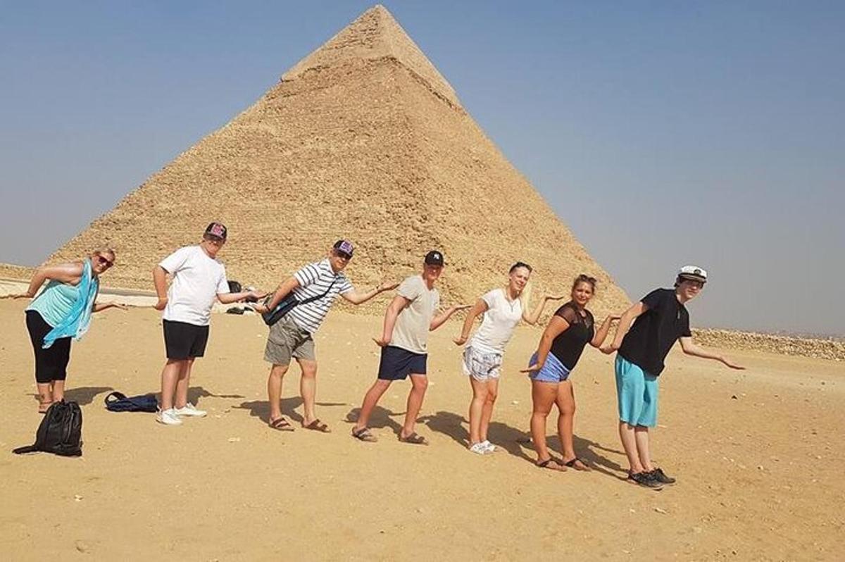 um grupo de pessoas em pé em frente à pirâmide