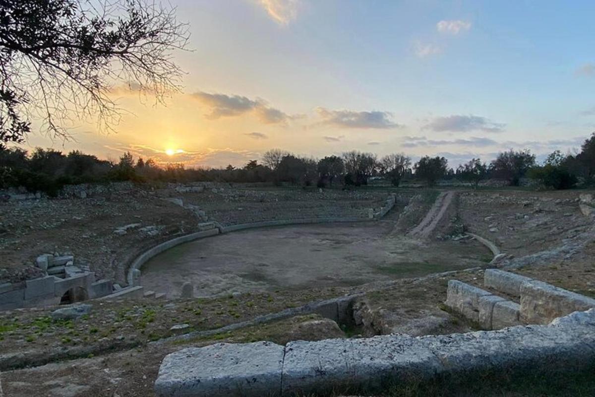 un amfiteatru cu soarele apunând pe un câmp