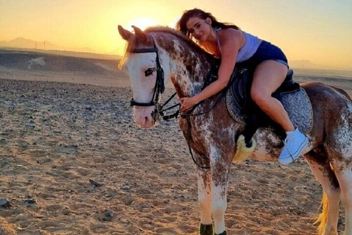 una donna a cavallo sulla spiaggia