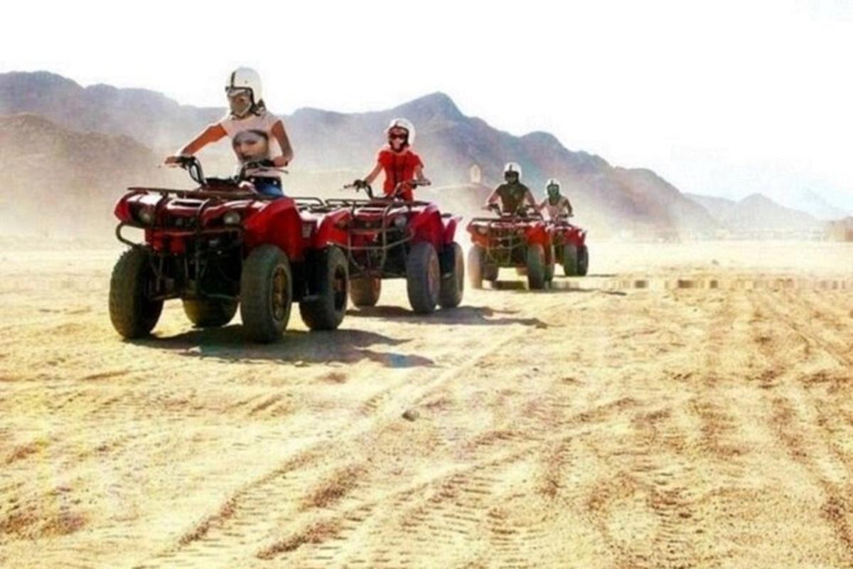 un gruppo di persone in sella a quad nel deserto
