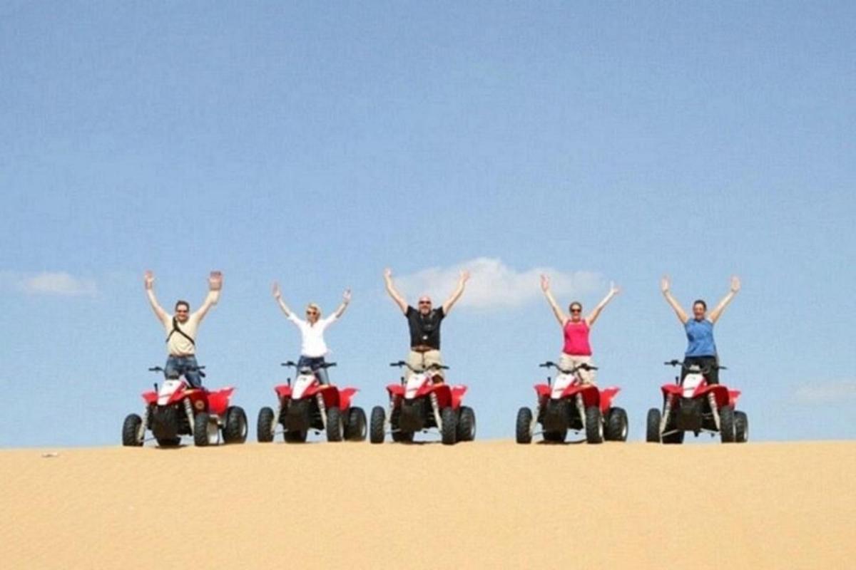 un gruppo di persone su quad nella sabbia