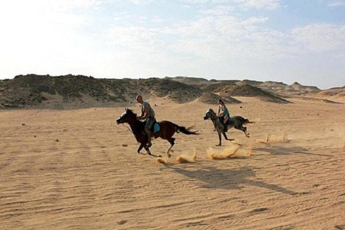 zwei Personen reiten in der Wüste