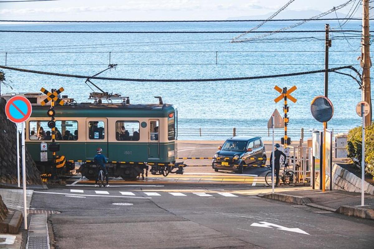 ένα πράσινο τρένο που οδηγεί σε έναν δρόμο δίπλα στον ωκεανό
