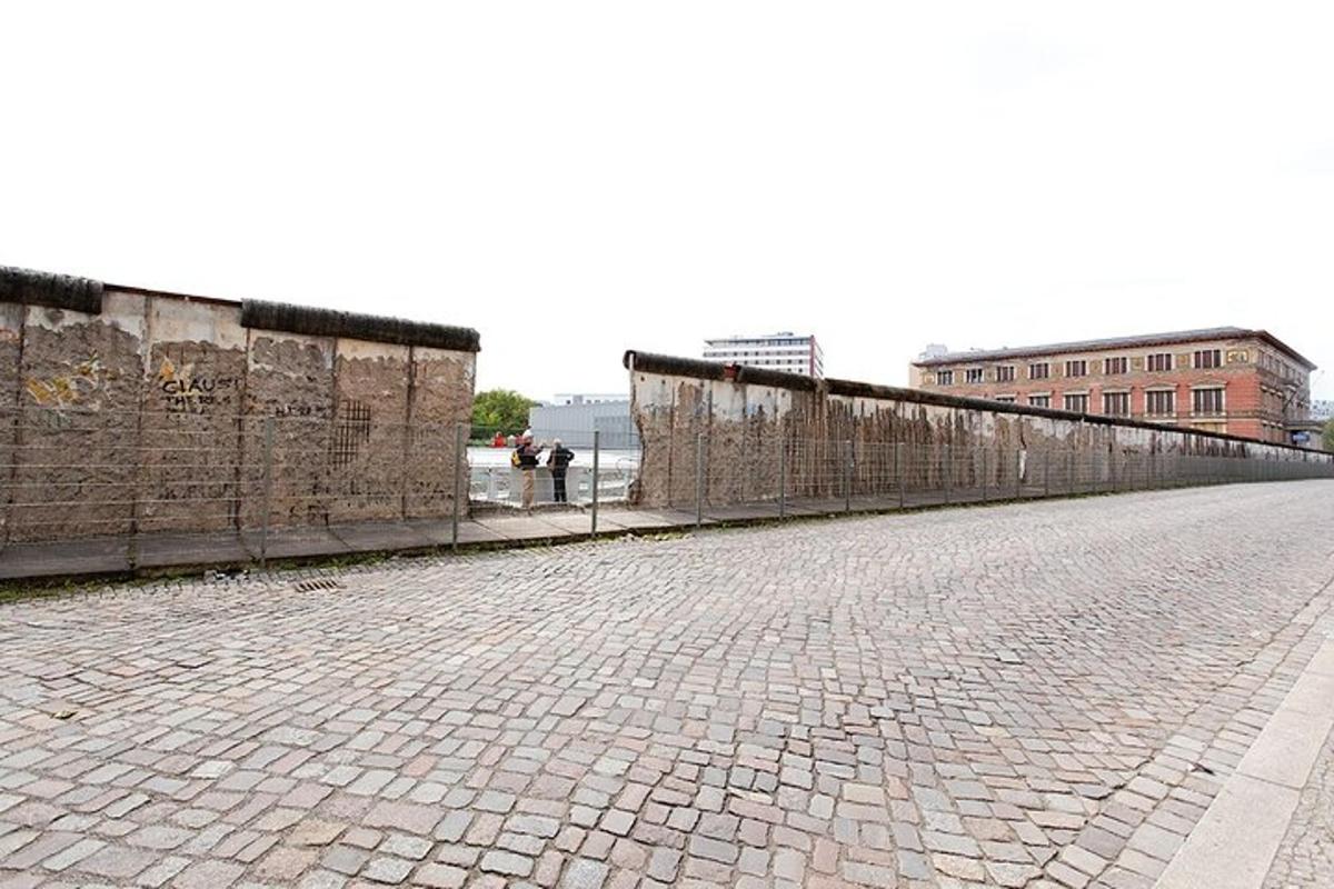 an empty street with a fence and a brick wall