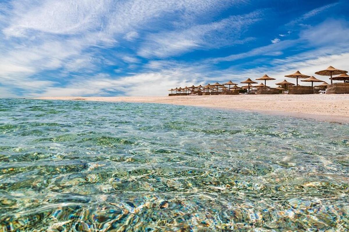 a beach with umbrellas and the crystal clear water