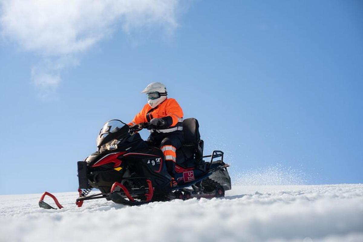 vyras važiuoja sniego motociklu sniege