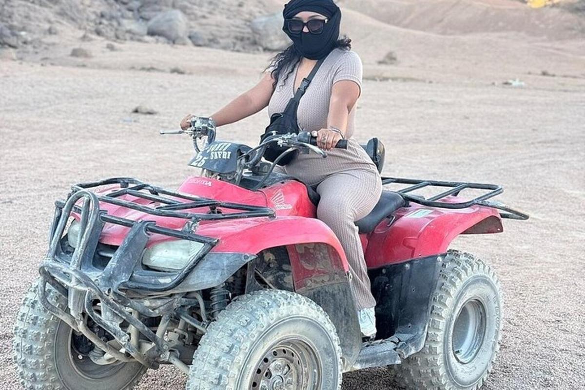 Μια γυναίκα κάθεται σε ένα τετράτροχο στην έρημο