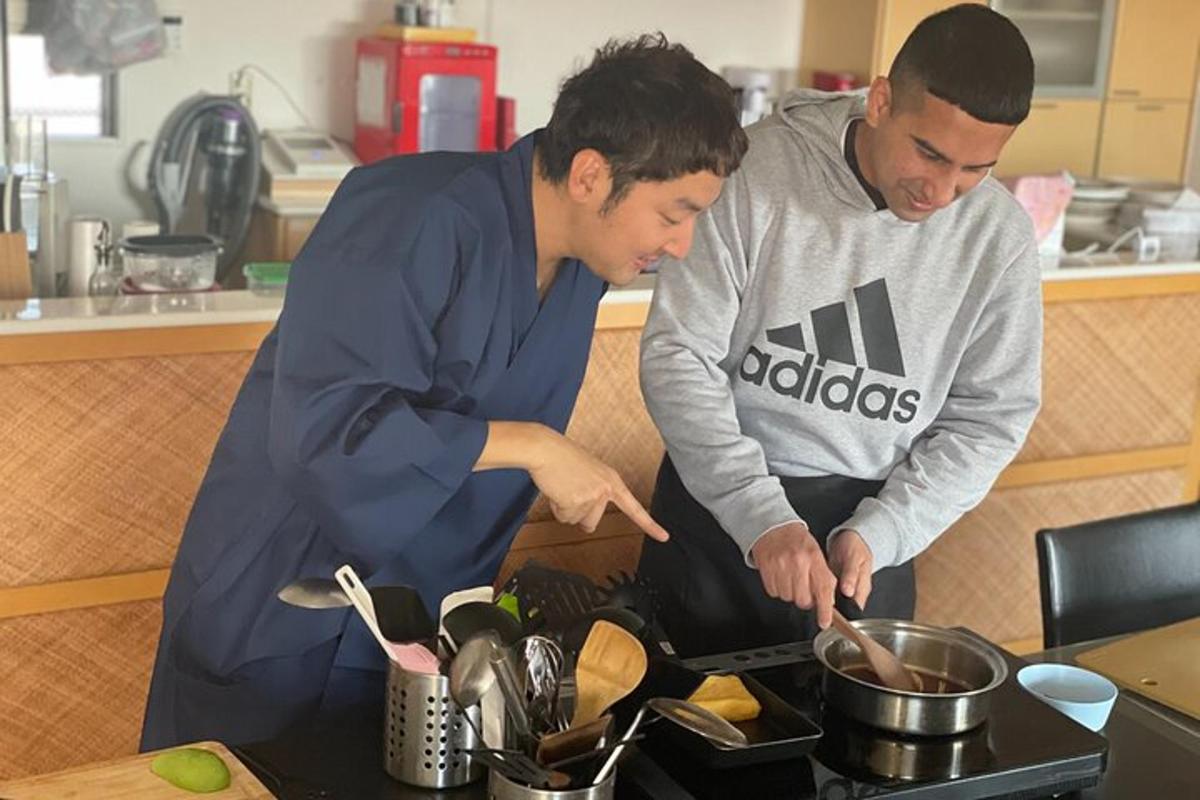 dua pria di dapur sedang menyiapkan makanan di atas kompor