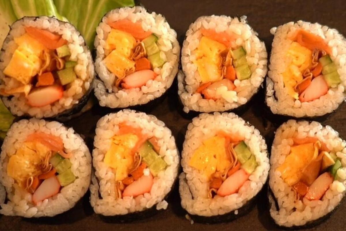 sekumpulan sushi gulung duduk dalam kotak