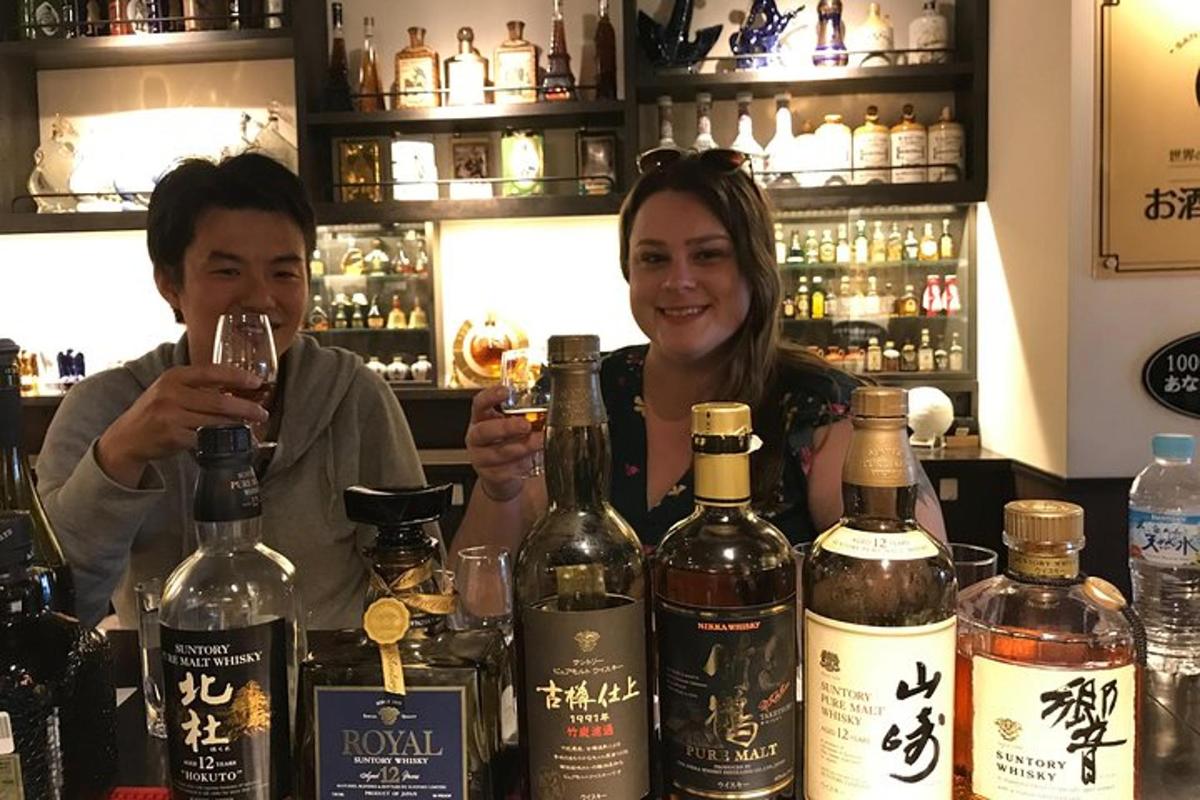 un home i una dona asseguts en un bar amb copes de vi