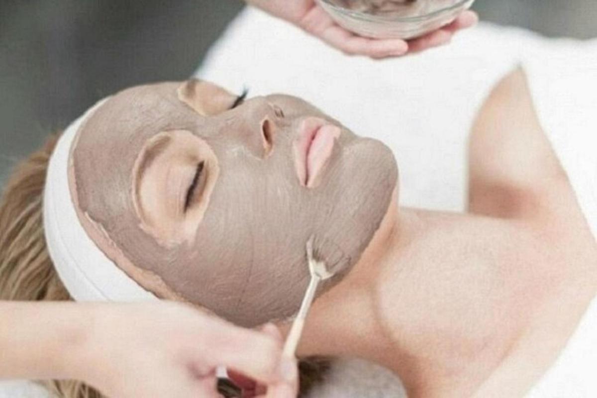 žena s maskom na licu pere zube