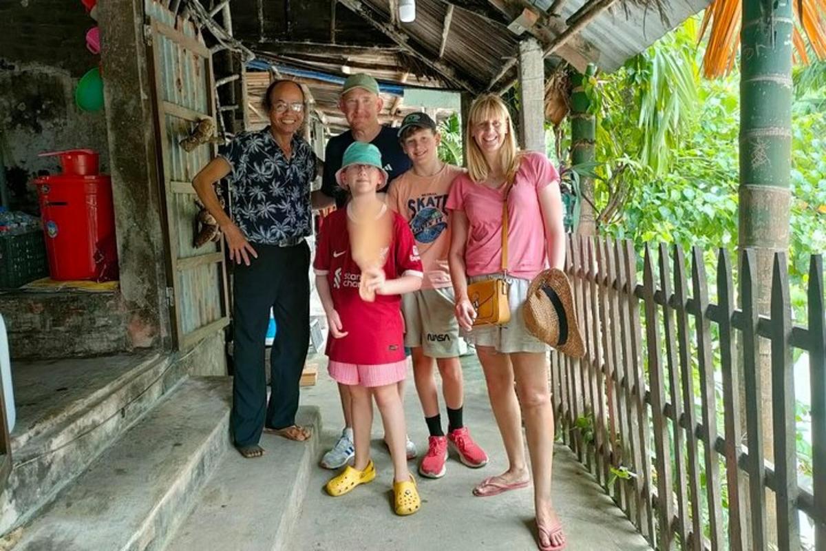 satu keluarga bergambar di hadapan rumah