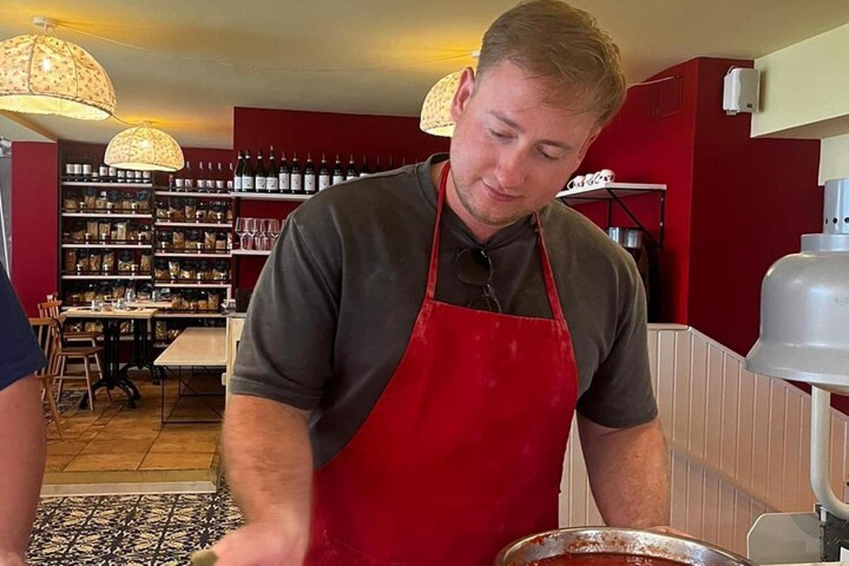 Un hombre con un delantal rojo preparando comida en una cocina.