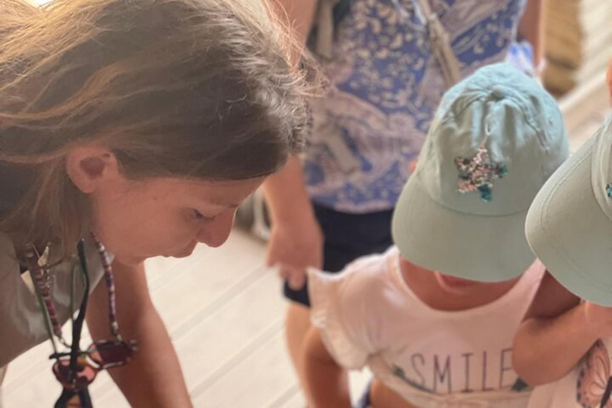 a woman standing next to a little girl with a hat