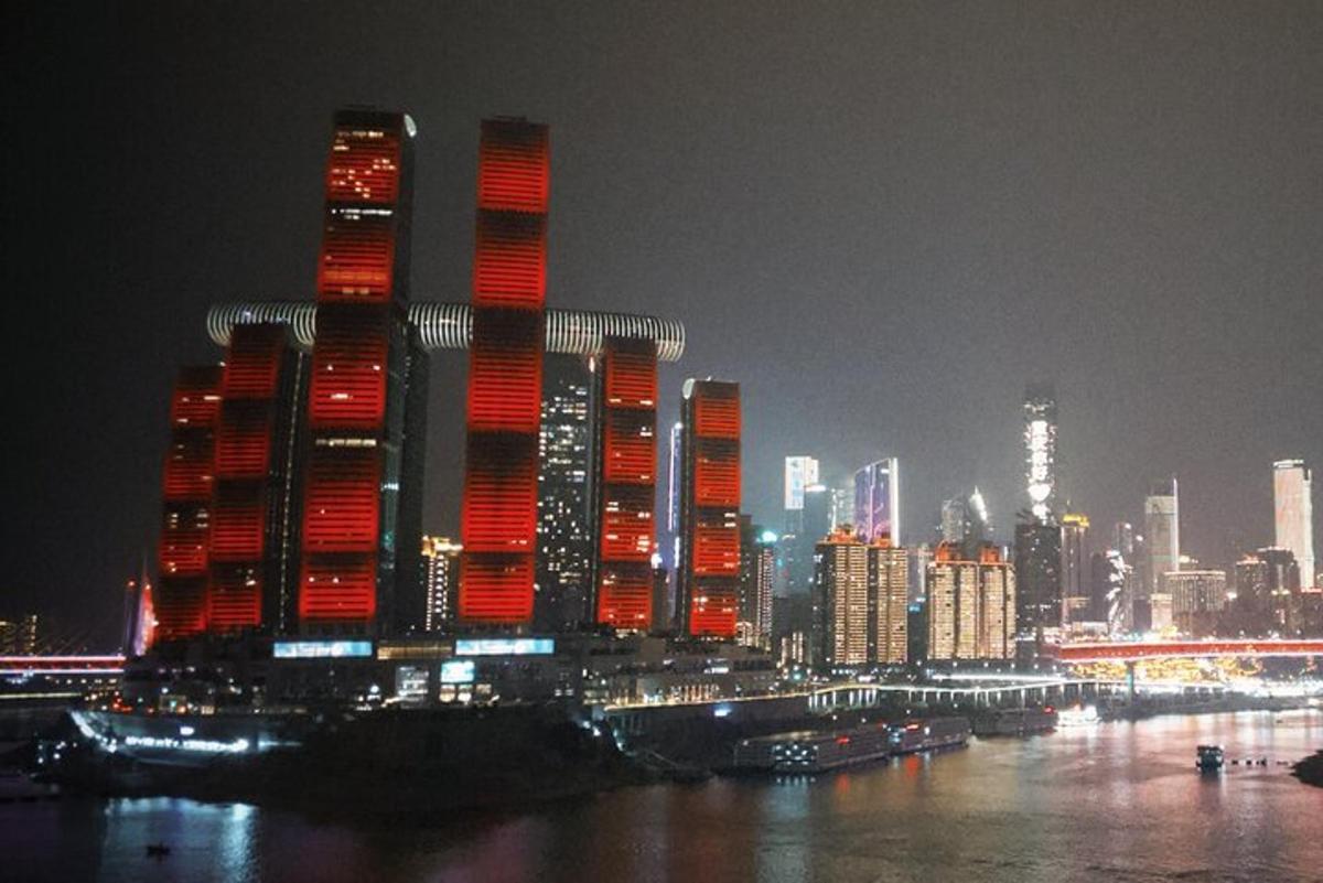 a tall building with red lights on it at night