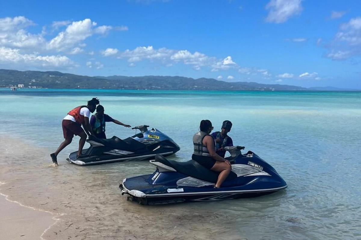 un grup de oameni care se plimbă pe jet ski-uri pe plajă