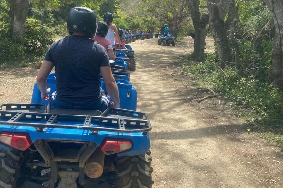 un grup de oameni care călătoresc pe ATV-uri pe un drum de pământ