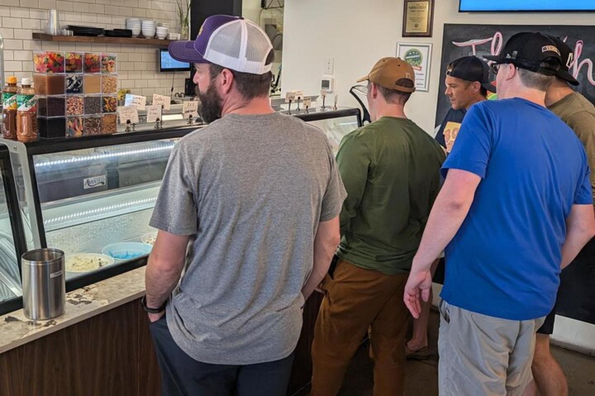 a group of men standing in a kitchen preparing food