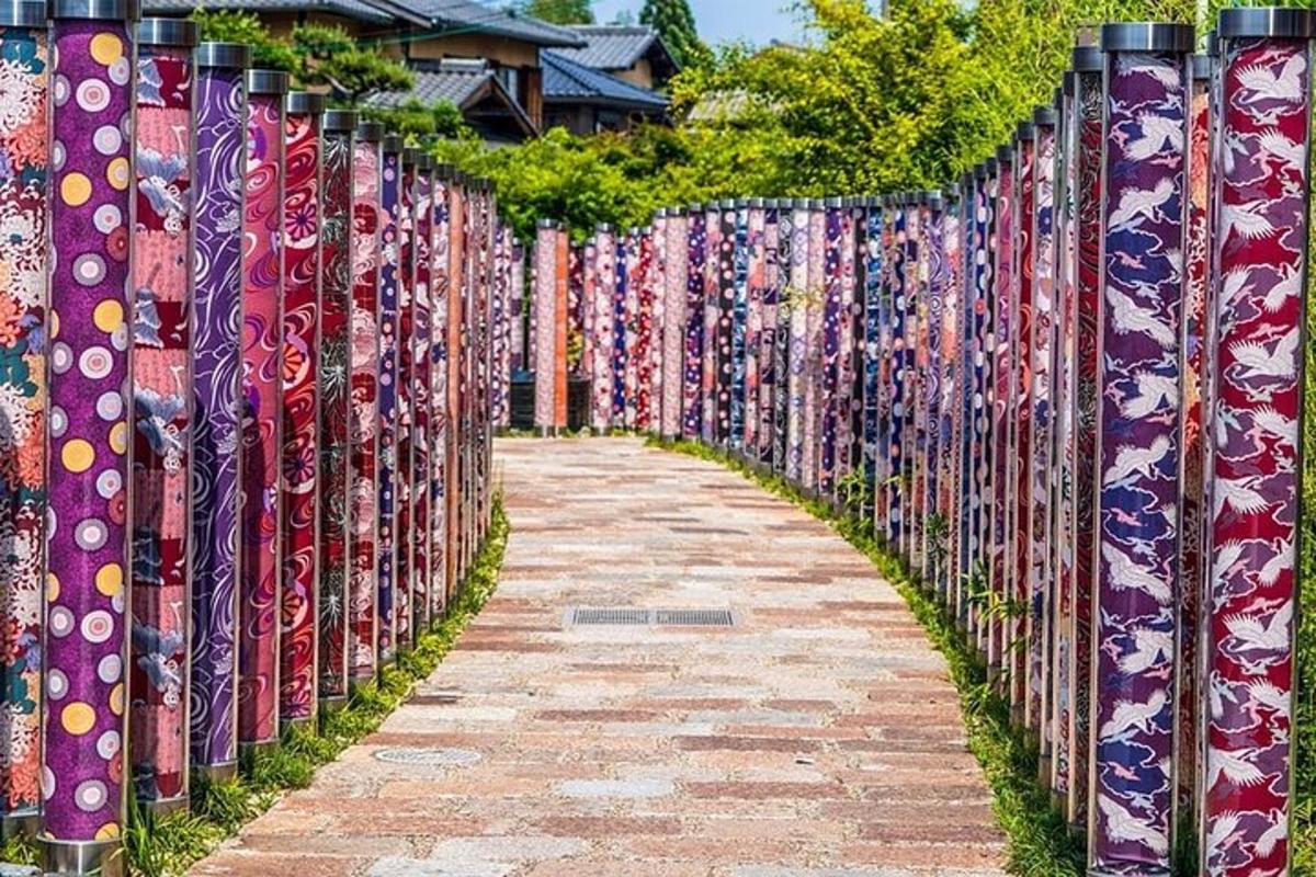 a fence covered in colorful ties on a sidewalk