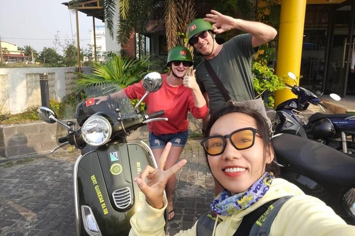 sekumpulan tiga orang berdiri di sebelah motosikal