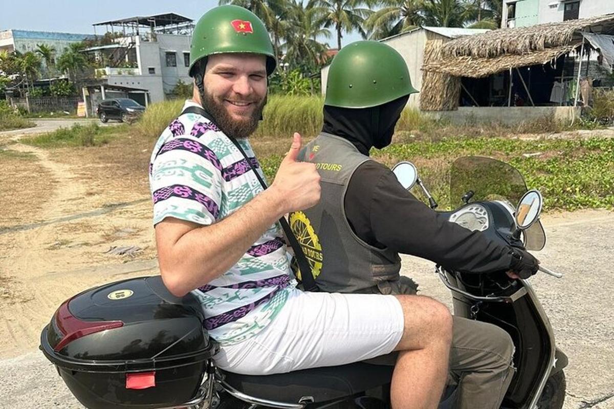 muž jedoucí na motorce s mužem ukazujícím palec nahoru