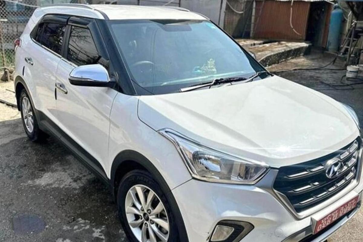 bílé auto zaparkované na parkovišti