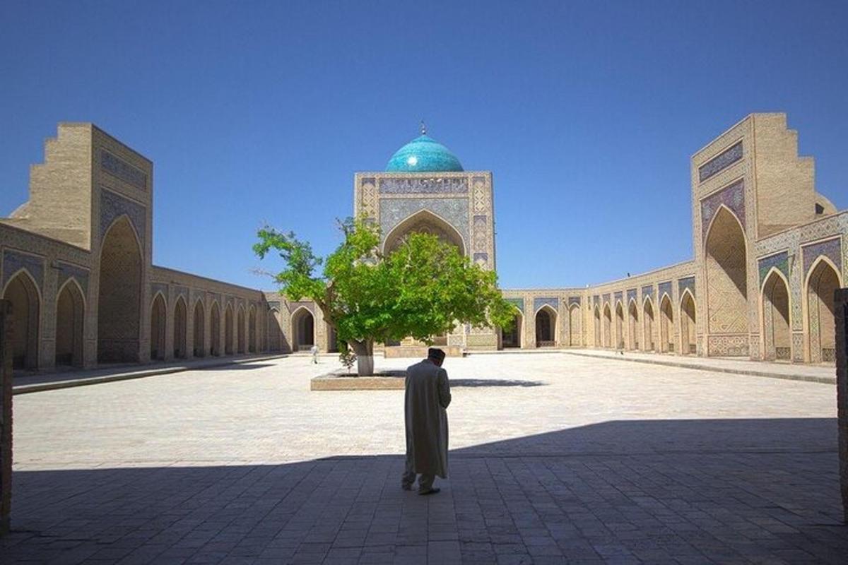 a man standing in front of a building with a mosque