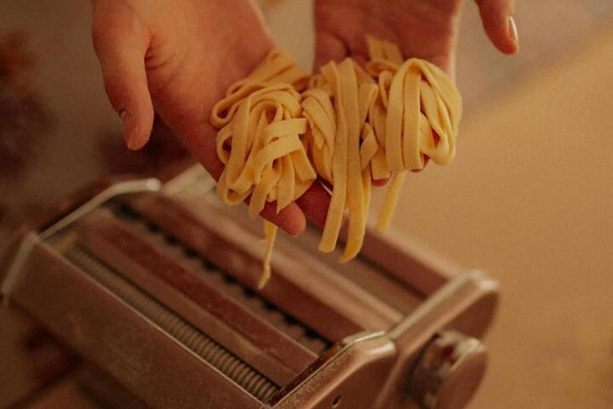 o persoană care ține o bucată de paste într-un prăjitor de pâine