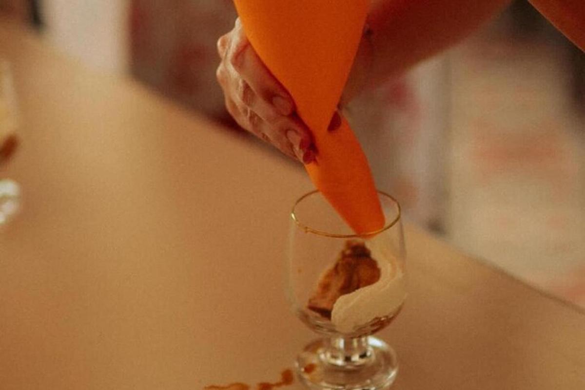 o persoană care toarnă un morcov într-un pahar de vin