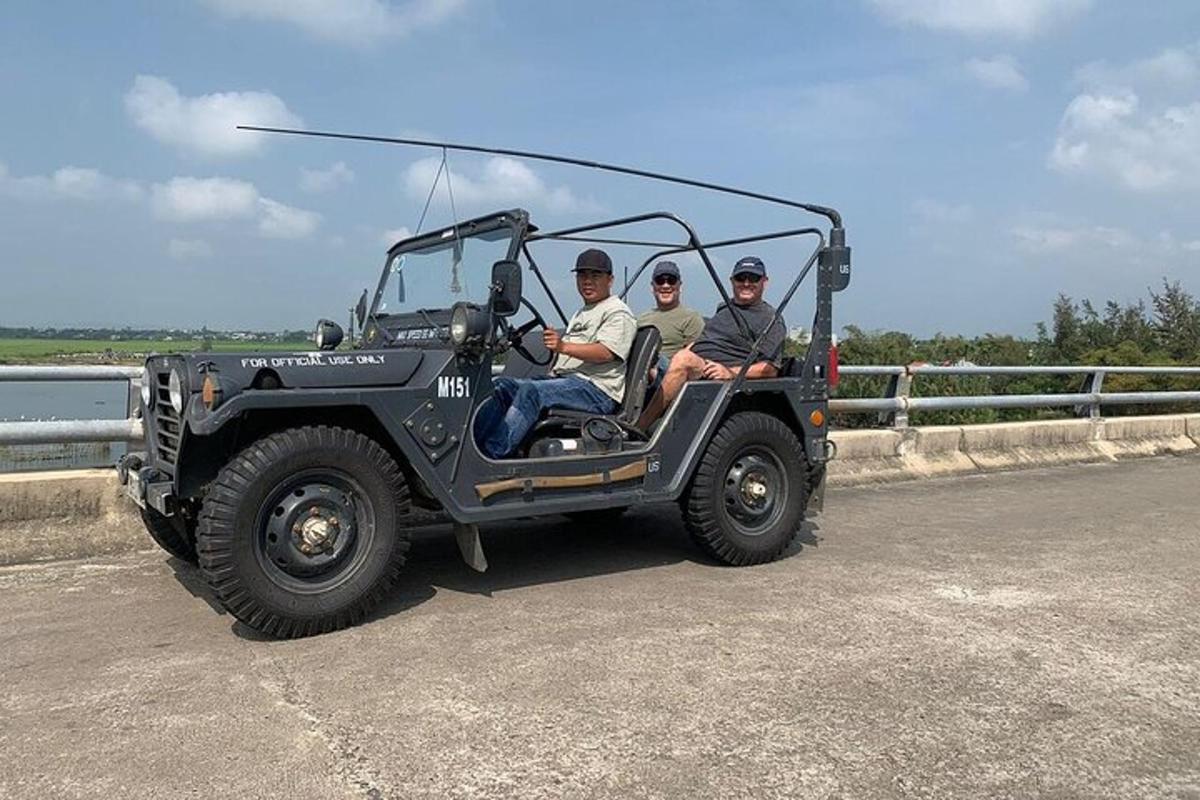 three people in a jeep driving on a road
