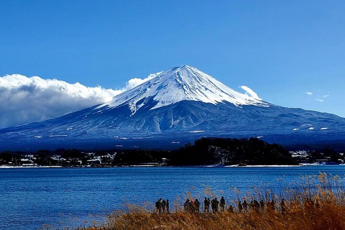 una muntanya coberta de neu davant d'una massa d'aigua