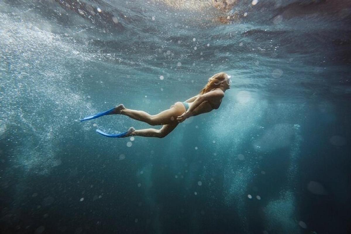 フリスビーを持って水中で泳ぐ女性
