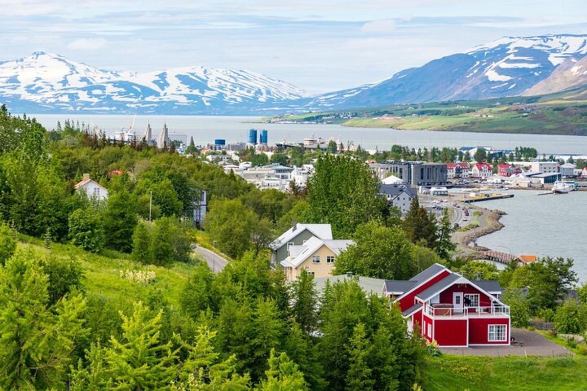 a small town on a hill with snow covered mountains