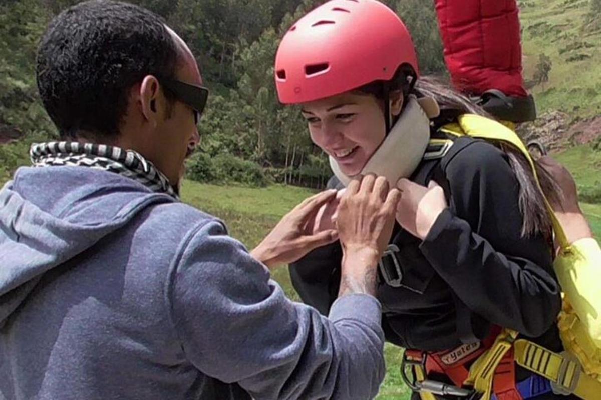 un uomo sta aiutando una donna che indossa un casco