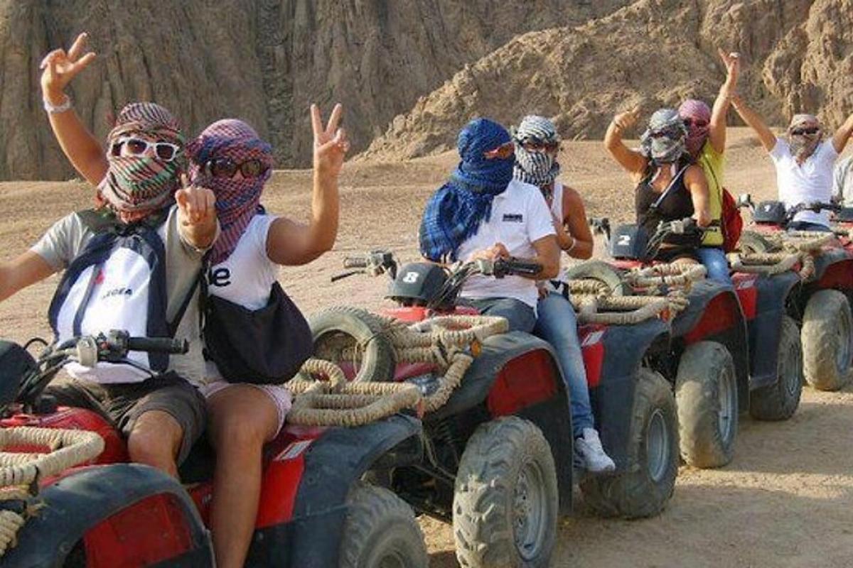 um grupo de pessoas andando de moto no deserto