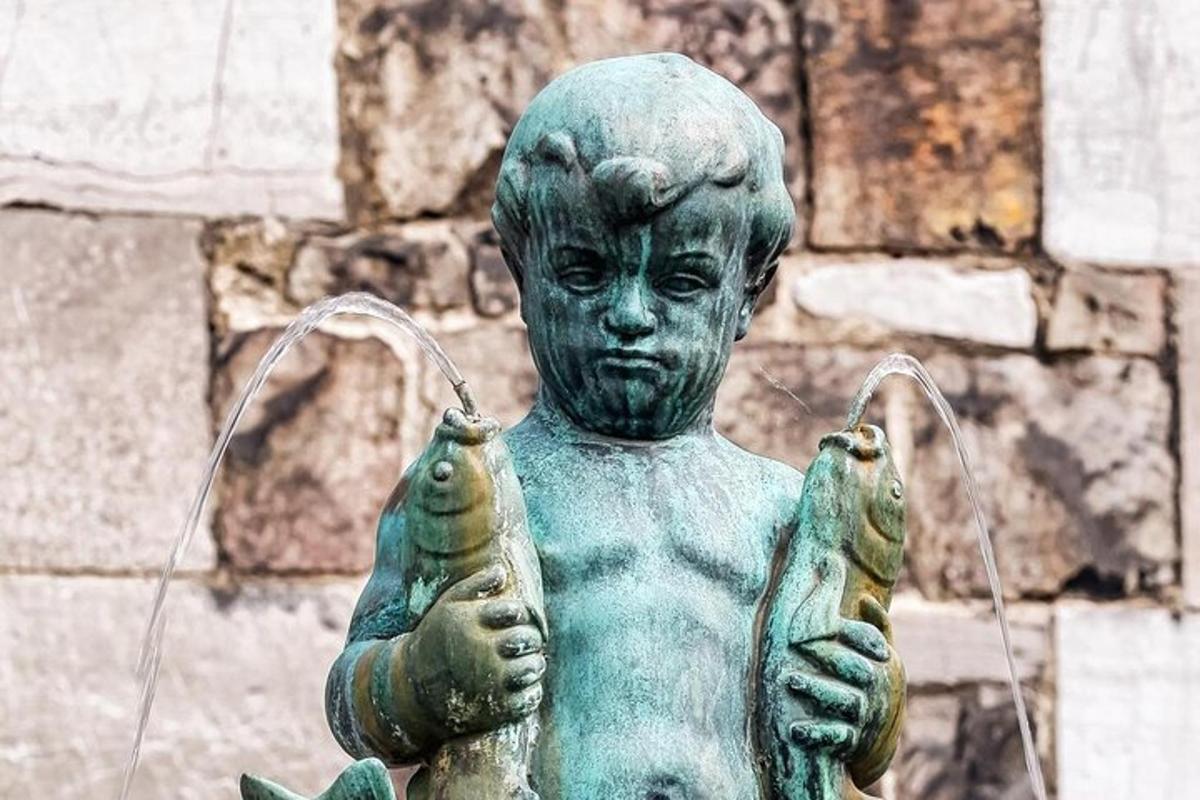 una statua di un giovane ragazzo che tiene in mano due pesci