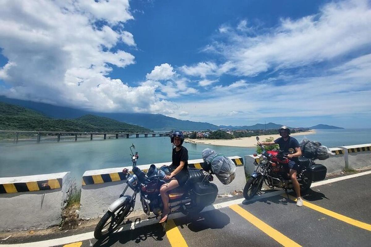 két ember motorozik egy úton a víz közelében