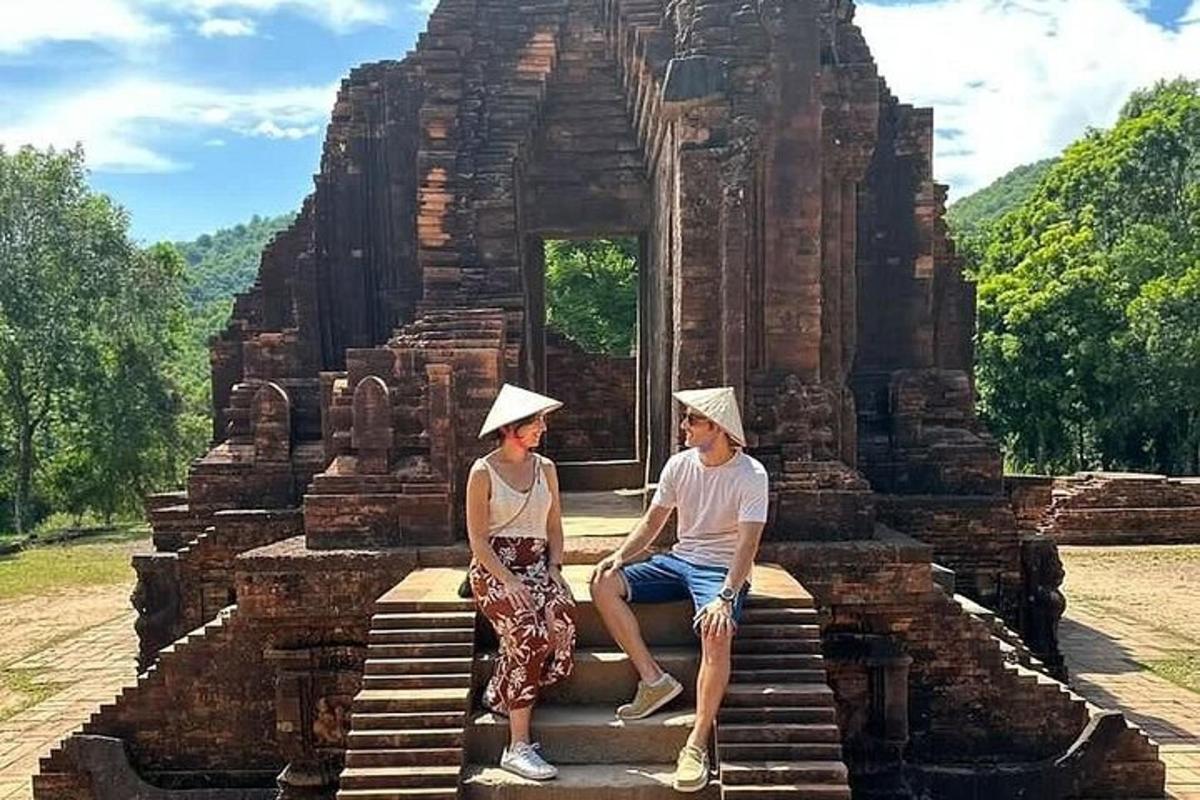 một người đàn ông và một người phụ nữ đang ngồi trên bậc thềm của một ngôi đền