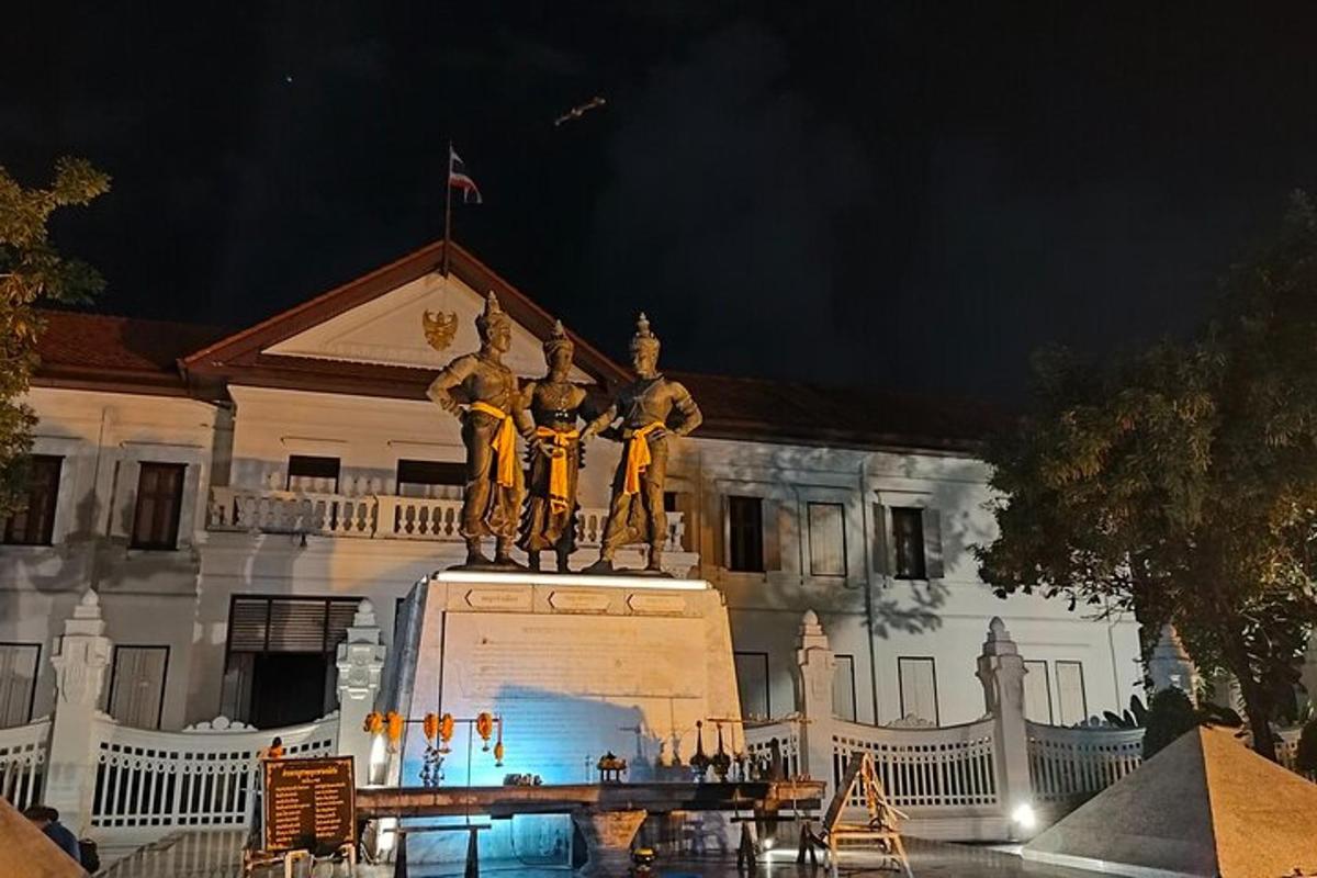 a statue in front of a building at night